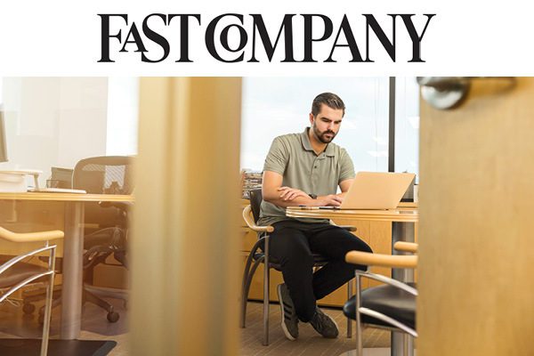 Fast Company someone sitting at a desk typing on laptop