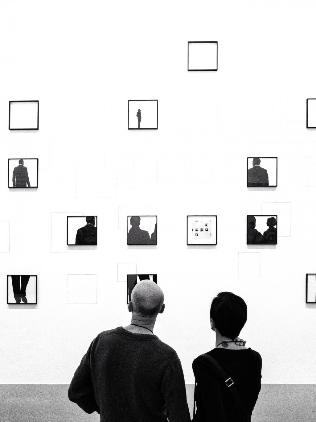 people looking at a wall of art 