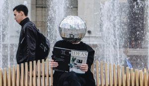 someone sitting with a disco on head
