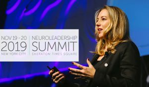 Photo of Dr. Tessa V. West on NeuroLeadership Summit stage with 2019 Summit dates overlayed