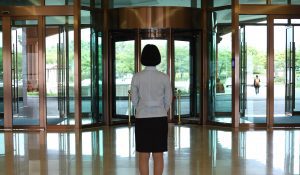 person's back standing looking at revolving door