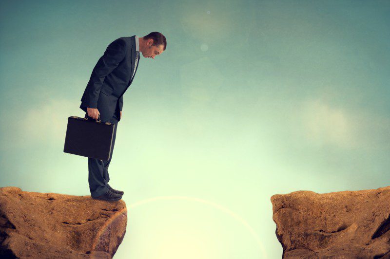 man in business suit standing on the edge of a cliff
