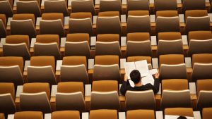 man sitting in an empty auditorium