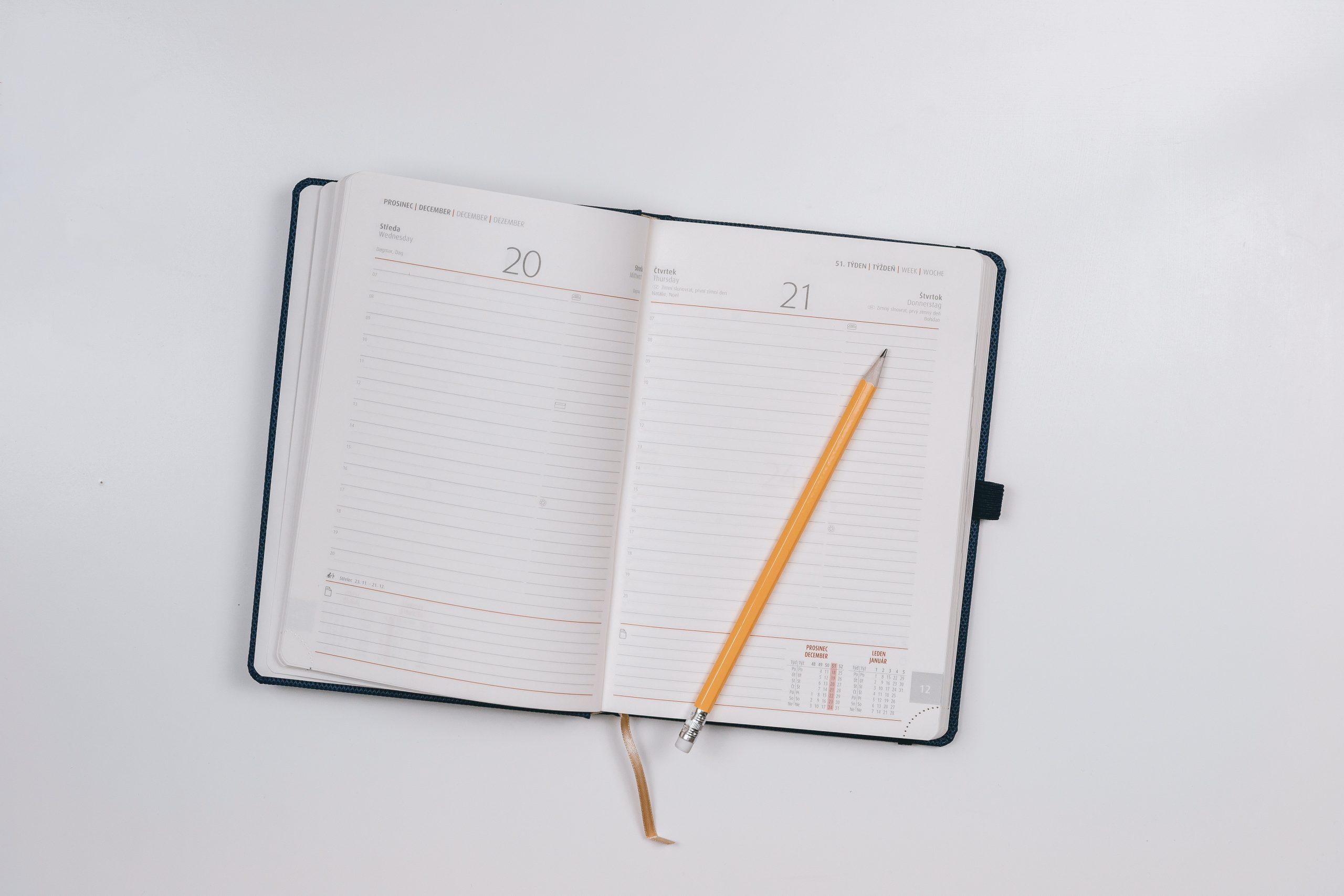 An open agenda notebook with pencil