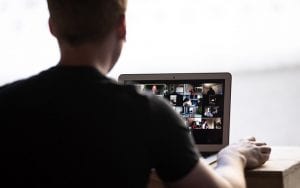 man sitting at laptop on video meeting