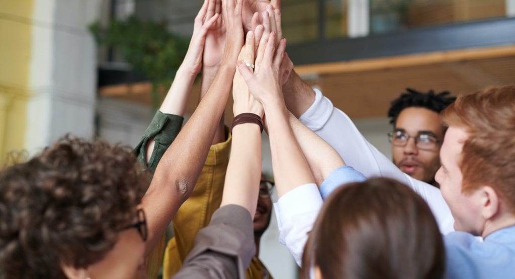 diverse group of coworkers sharing a group high five
