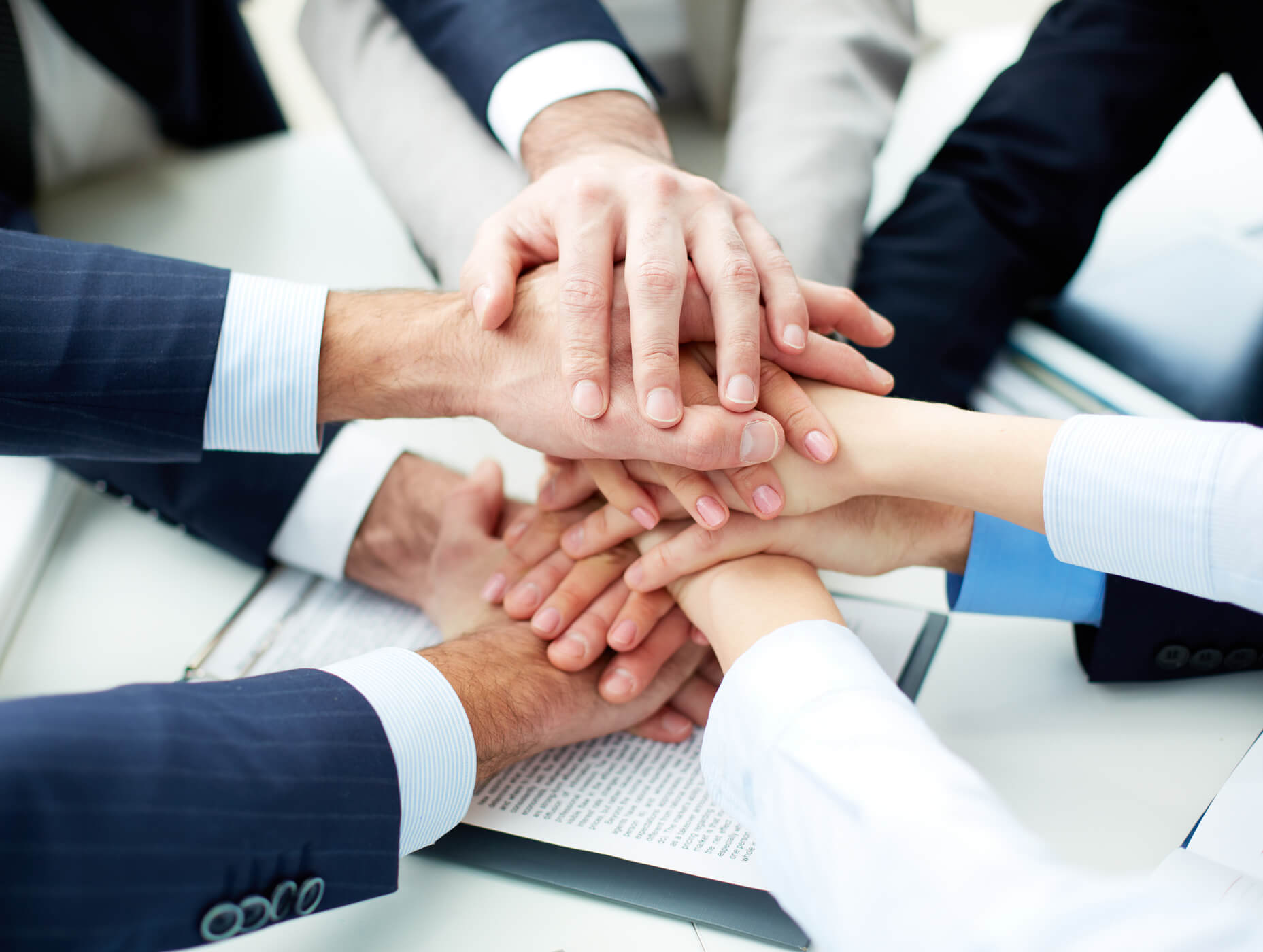 close-up-of-business-partners-making-pile-of-hands-at-meeting-SBI-300739596_50