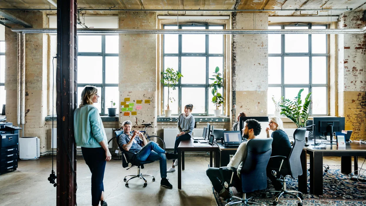 Group of people have a meeting in an office and are in discussion, smiling