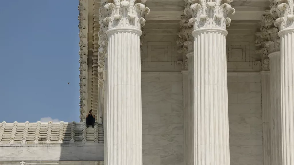 US Supreme Court Officer sits on top of the Supreme Court Building to oversee protests occurring