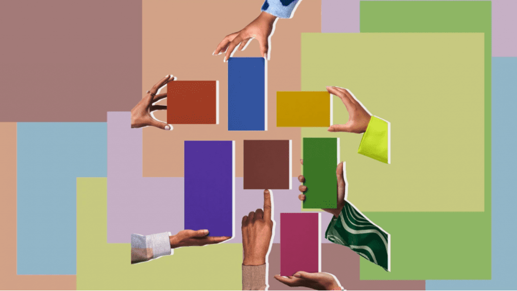 A diverse group of hands hold different colored blocks toward each other