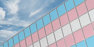 An office building with lines of windows colored in blue, pink, and white